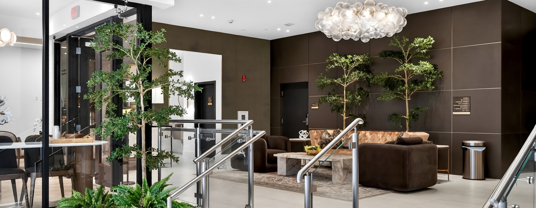 Modern lobby at The Holly apartments in downtown Hollywood, FL featuring contemporary seating, high ceilings, and a welcoming resident lounge.