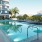a swimming pool with chairs and umbrellas next to a building