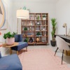 an office room with a chair, table and a bookshelf