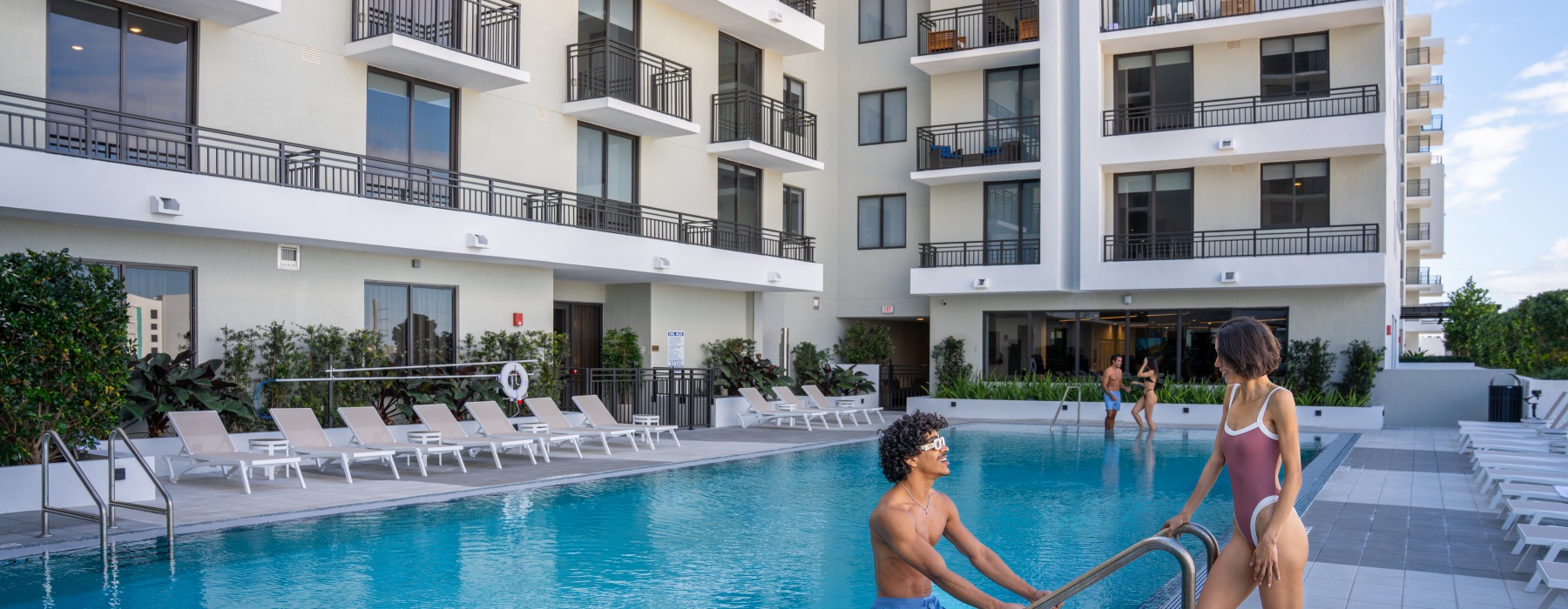 Residents relaxing by the resort-style swimming pool at The Holly at Soleste apartments in Hollywood, FL.