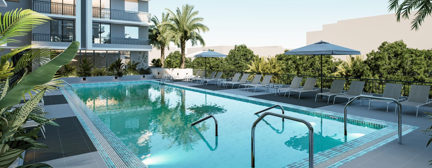 a swimming pool with chairs and umbrellas next to a building